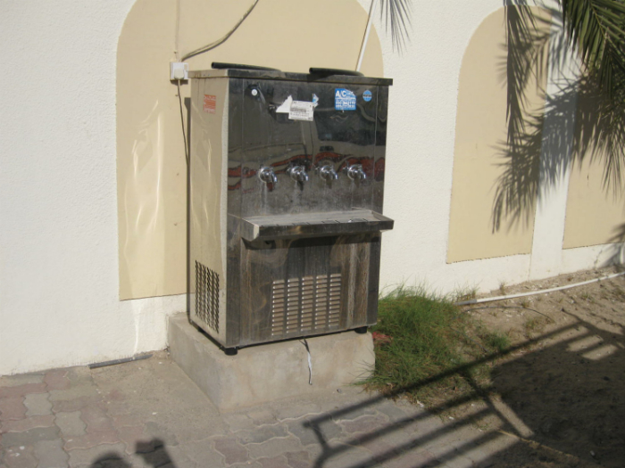 Cool water dispenser made available by community minded owner of the house behind the fence.